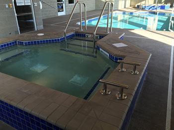 A large indoor pool with a diving board and a ladder into the water